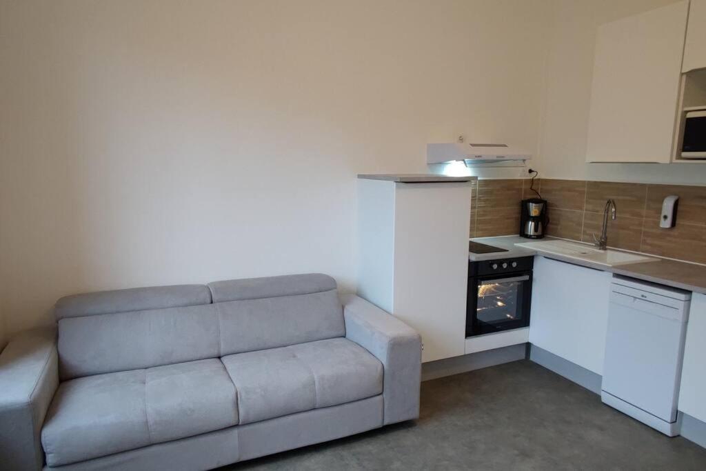 a living room with a couch in a kitchen at TOK TOK S2 - Appartement 1Ch Plein cœur de Seclin in Seclin