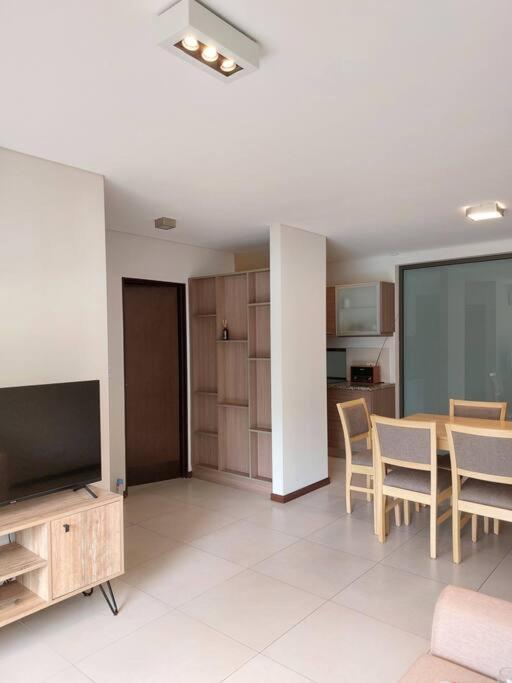 a living room with a television and a table and chairs at GALA Dptos. Temp. Condominios del Alto in Rosario
