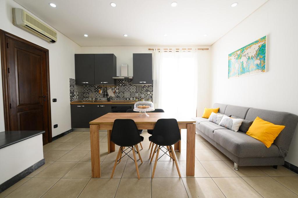 eine Küche und ein Wohnzimmer mit einem Tisch und einem Sofa in der Unterkunft Alleria in Comiso
