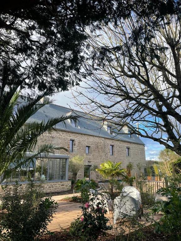 un grand bâtiment en briques avec un toit dans l'établissement Domaine de l'O, à Gatteville-le-Phare