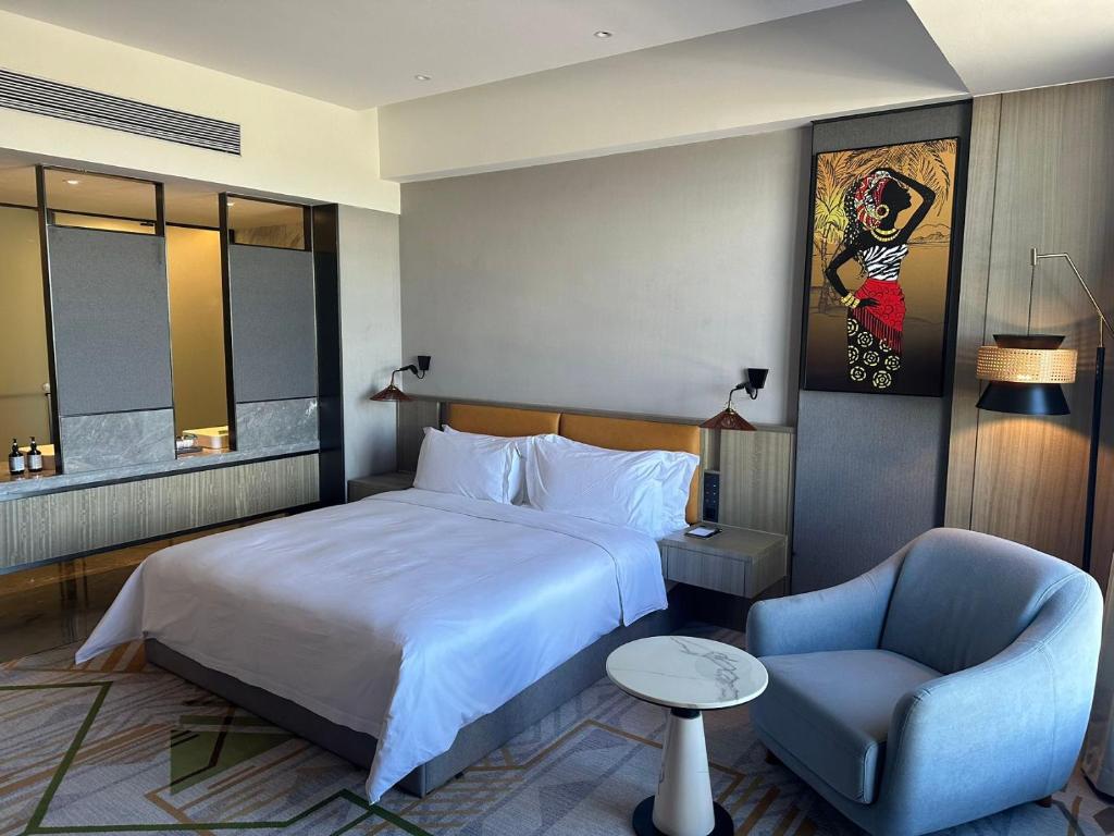 a hotel room with a bed and a chair at Argyle Grand Hotel Nairobi Airport in Nairobi