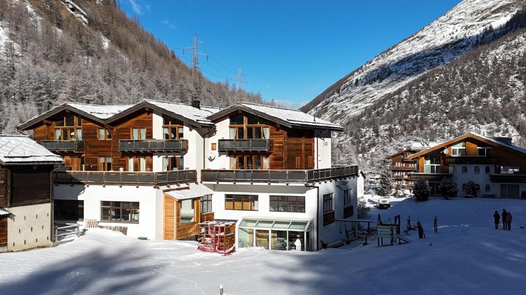 um alojamento de esqui na neve em frente a uma montanha em Appartement Flora em Saas-Almagell