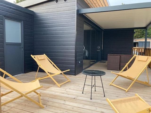 un patio con 2 sillas y una mesa en una terraza en COTTAGE 4/5 pers, en Jullouville-les-Pins