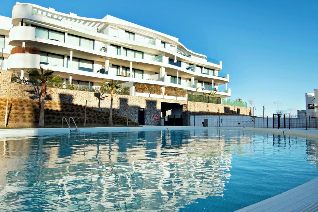 einem Pool vor einem Gebäude in der Unterkunft Mara's Apartments Higueron West - Modern Large Apartment - 50 metres of terrace with sea views and afternoon sun !!!! in Fuengirola