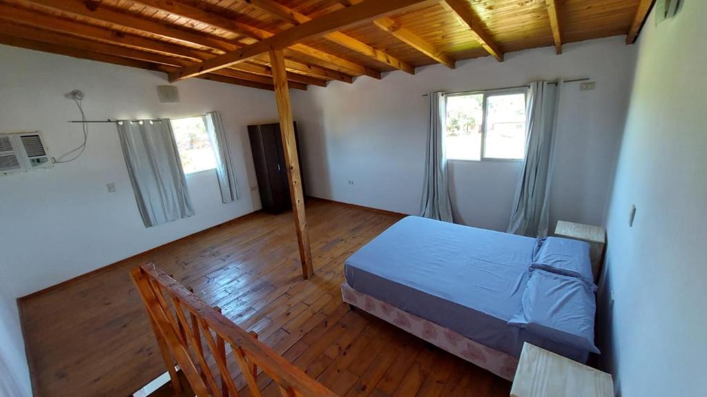 a bedroom with a bed and two windows at Ñandubay1 in Puerto Iguazú