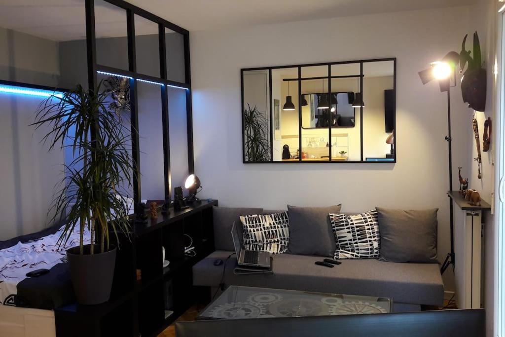 - un salon avec un canapé et un miroir dans l'établissement Superbe studio avec terrasse, à Courbevoie