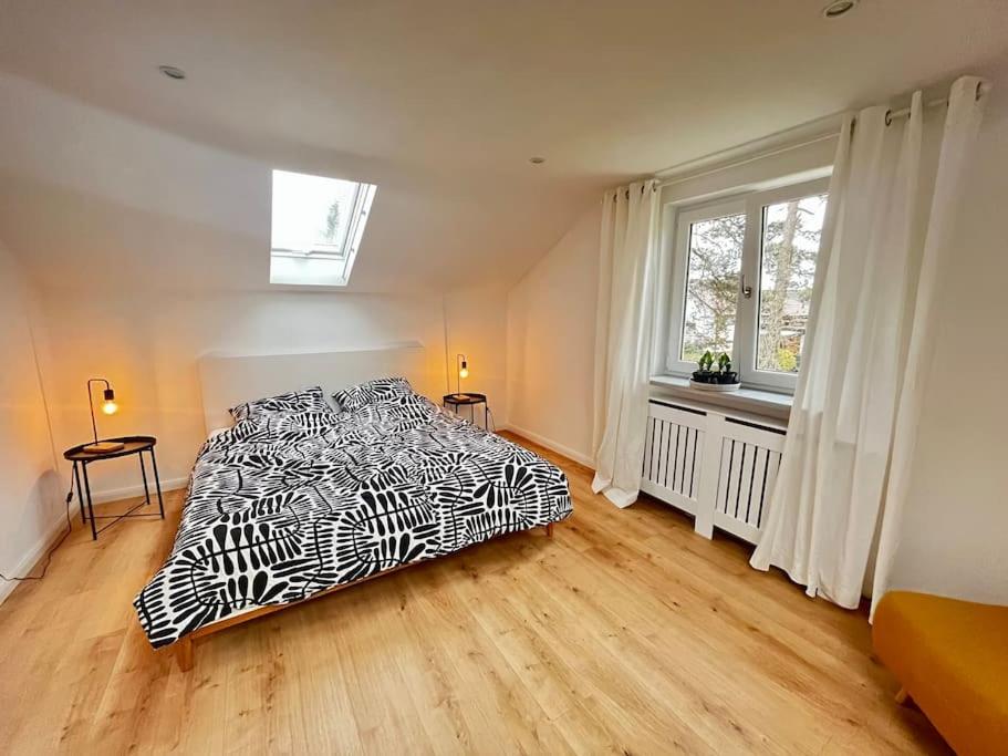a bedroom with a black and white bed and a window at Ferienwohnung im Grünen in Neustadt bei Coburg