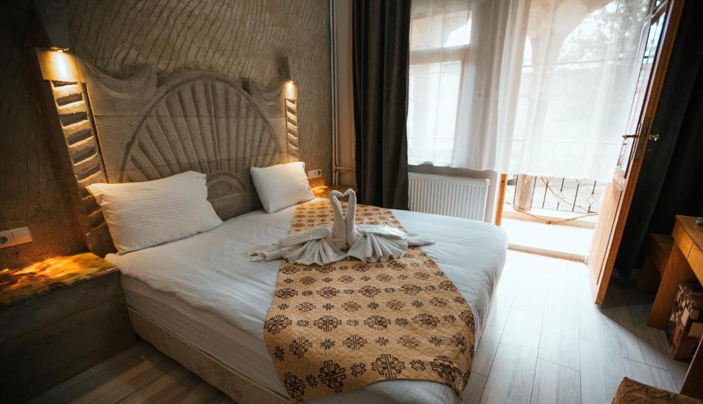 a bedroom with a bed with a blanket on it at tulpar hotel in Urgup