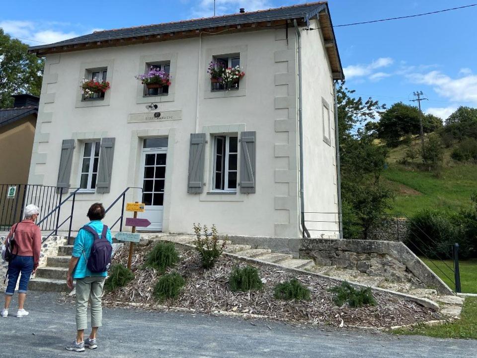 2 personnes debout devant une maison blanche dans l'établissement Etape cyclo- rando sur la VéloFrancette, à Montflours