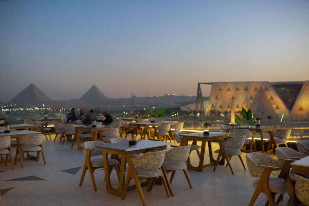 a group of tables and chairs on a roof with pyramids at Royal Great Pyramid INN in Cairo