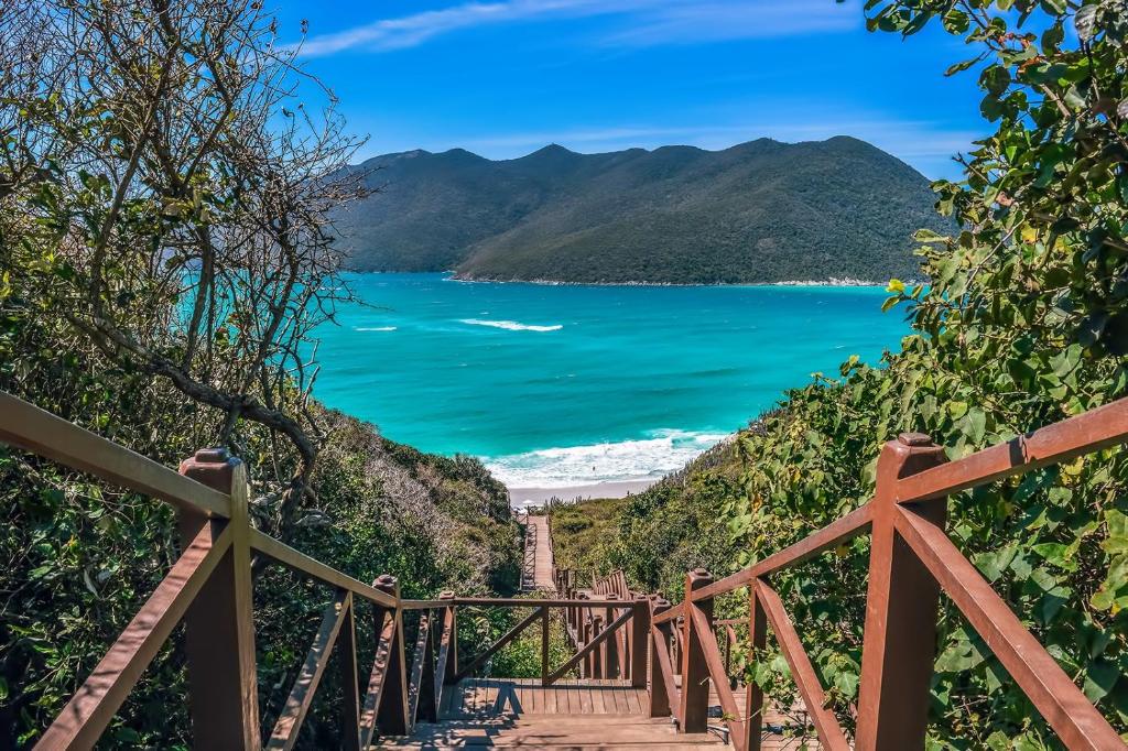 eine Treppe hinunter zum Strand mit dem Meer in der Unterkunft Casa no centro de Arraial do Cabo in Arraial do Cabo