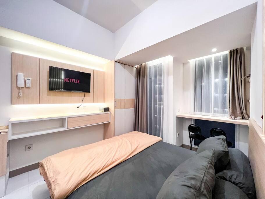 1 dormitorio con 1 cama y TV en la pared en Apt Tokyo Riverside Studio PIK2 Tower C w Netflix., 