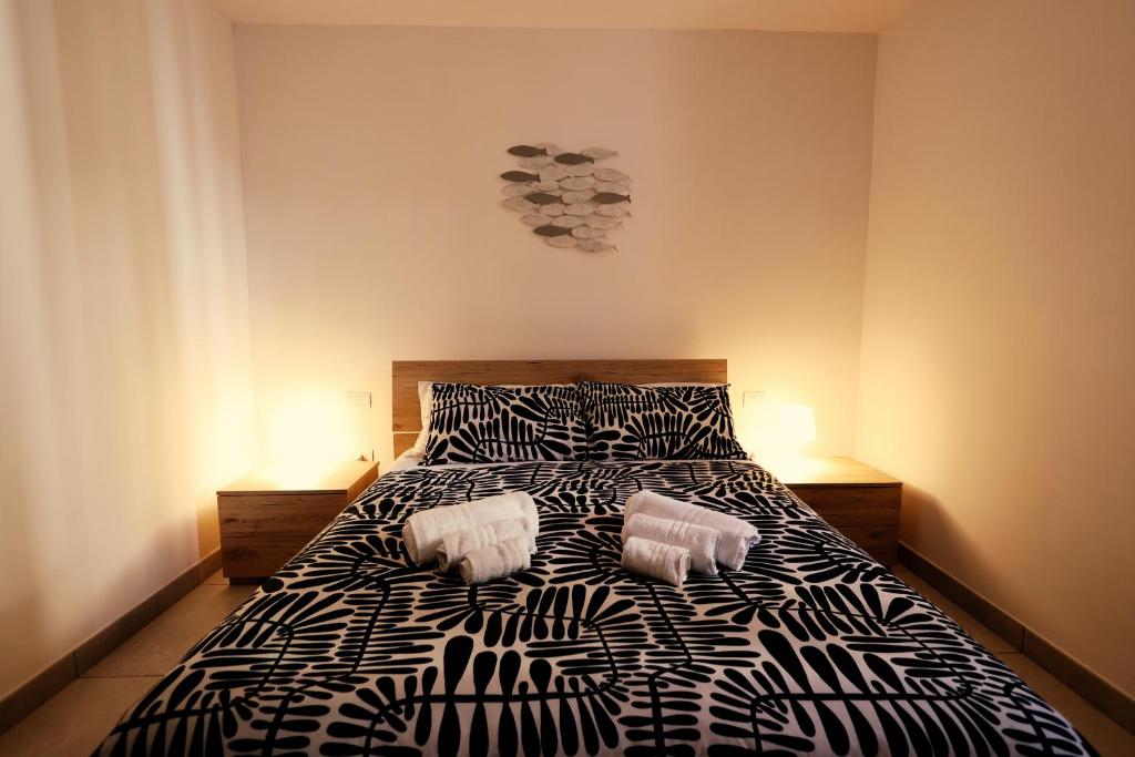 een slaapkamer met een zwart-wit bed met 2 kussens bij Casa Cicerone Lucrino in Pozzuoli
