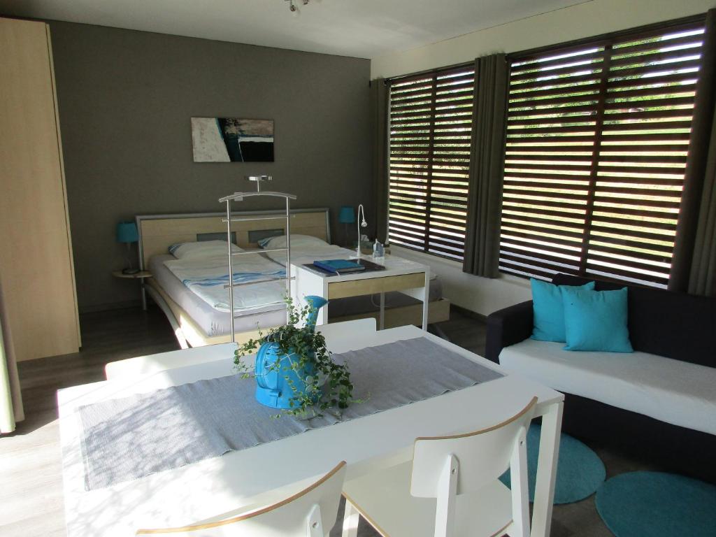 a living room with a table and a bed at Bnb Pavillon Paisible in Orsonnens