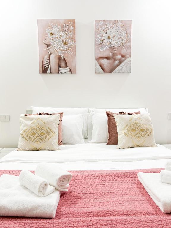 a bedroom with a white bed with towels on it at La casa di Alessia nel centro di Como - Alessiatravelling in Como