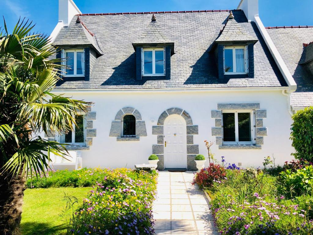 une maison blanche avec des fenêtres bleues et un chemin dans l'établissement Villa DUXCAAR Avel Mor, à Guissény