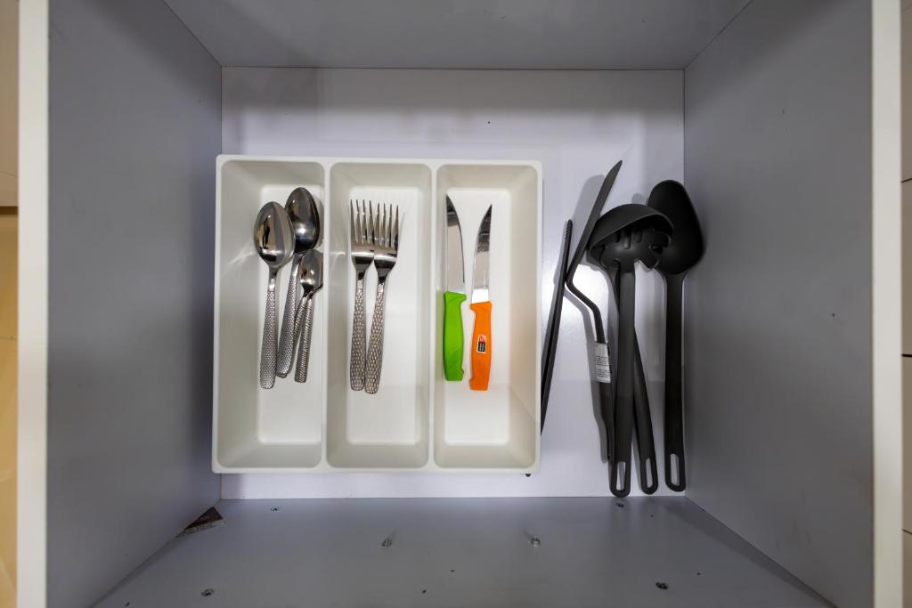 a utensil holder with cutlery in a drawer at Marron 3b in Cairo