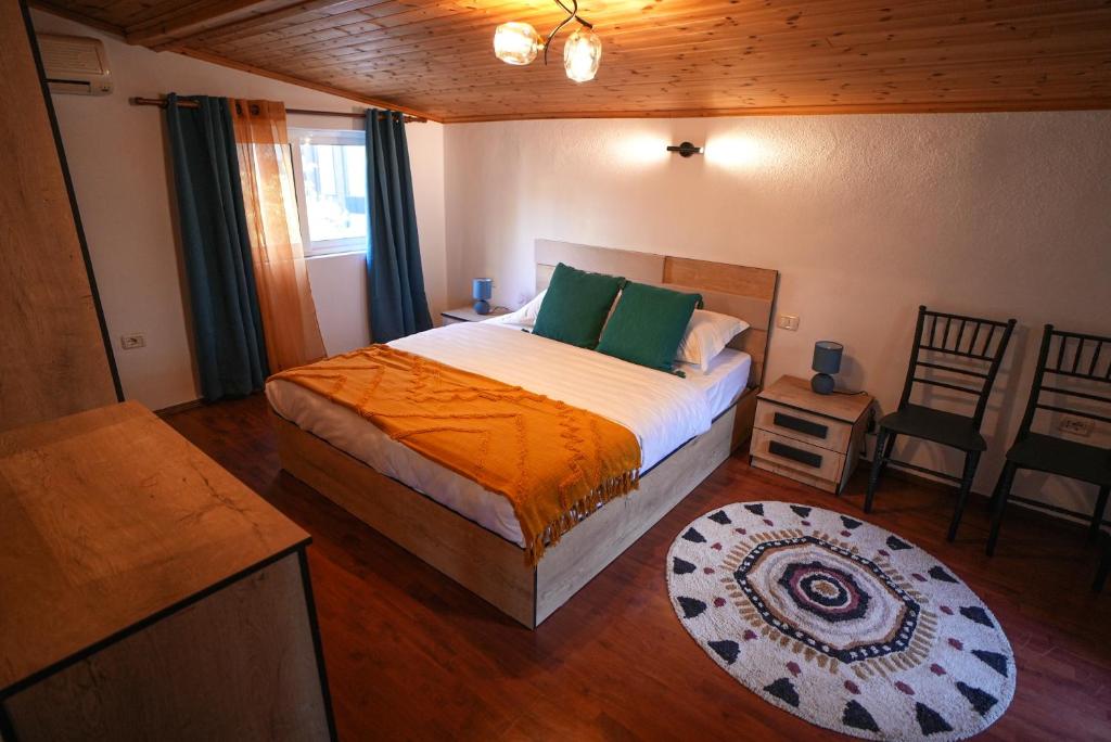 - une chambre avec un lit doté de draps orange et d'oreillers verts dans l'établissement Grandpa House-Attic App 4, à Tirana