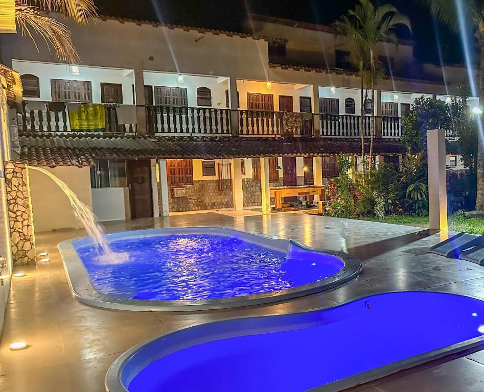 une grande piscine bleue avec une fontaine en face d'une maison dans l'établissement Pousada Alfa, à Abraão