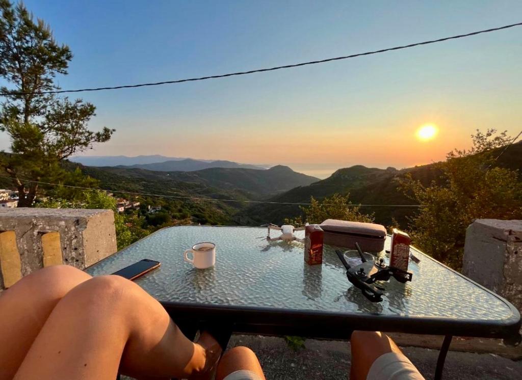 a person sitting at a table watching the sunset at Fabulous Villa in Monemvasia