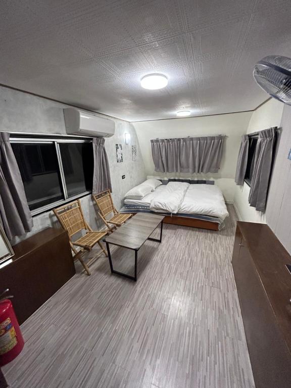 1 dormitorio con 1 cama y 1 sofá en un remolque en 巴斯拉岸民宿 en Chenggong