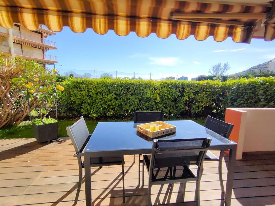 une table et des chaises bleues sur une terrasse dans l'établissement 2 pièces proche golf Mandelieu, à Mandelieu-la-Napoule