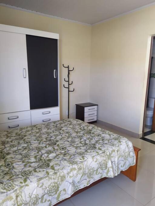 a bedroom with a bed and a large window at Quitinete para casal in Brasília