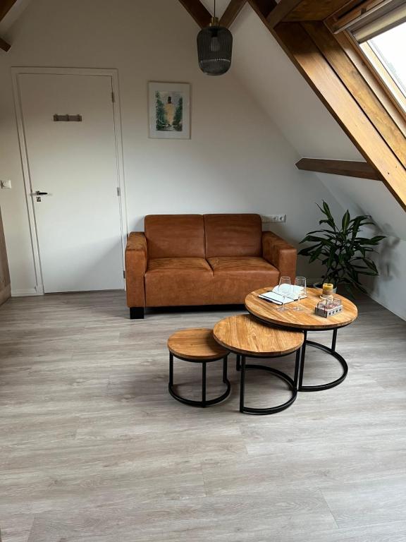 uma sala de estar com um sofá e duas mesas em Ruim appartement met sauna, Zuidstraat 125 in Westkapelle em Westkapelle