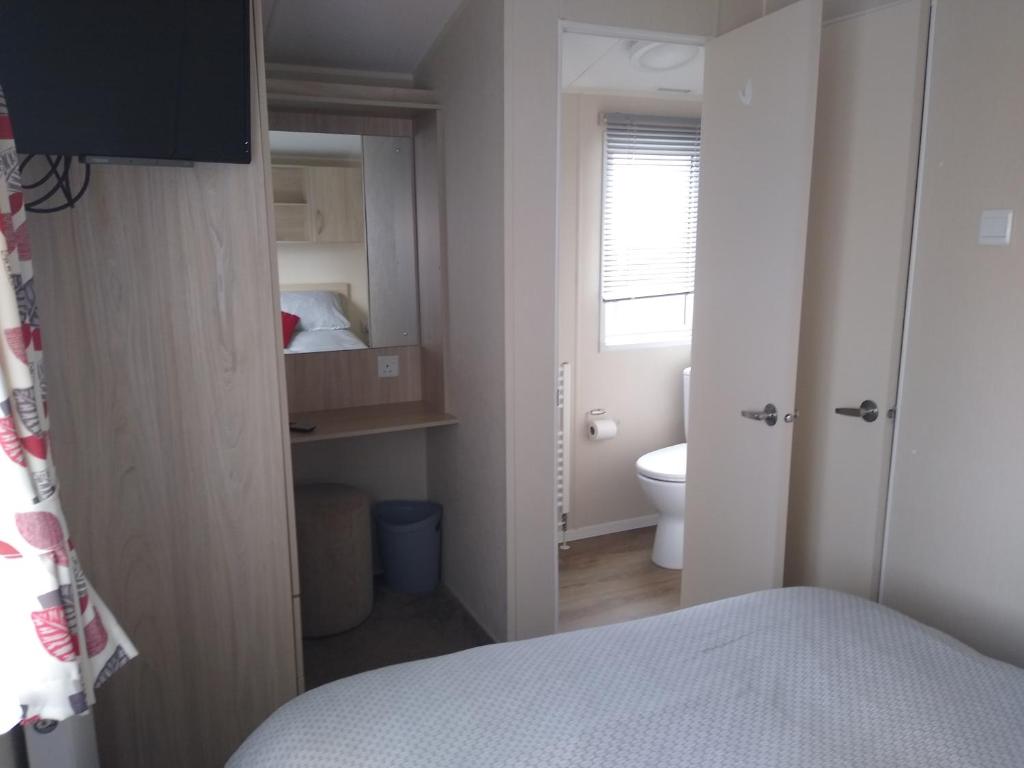 a small bedroom with a bed and a bathroom at CHANNI in Prestatyn