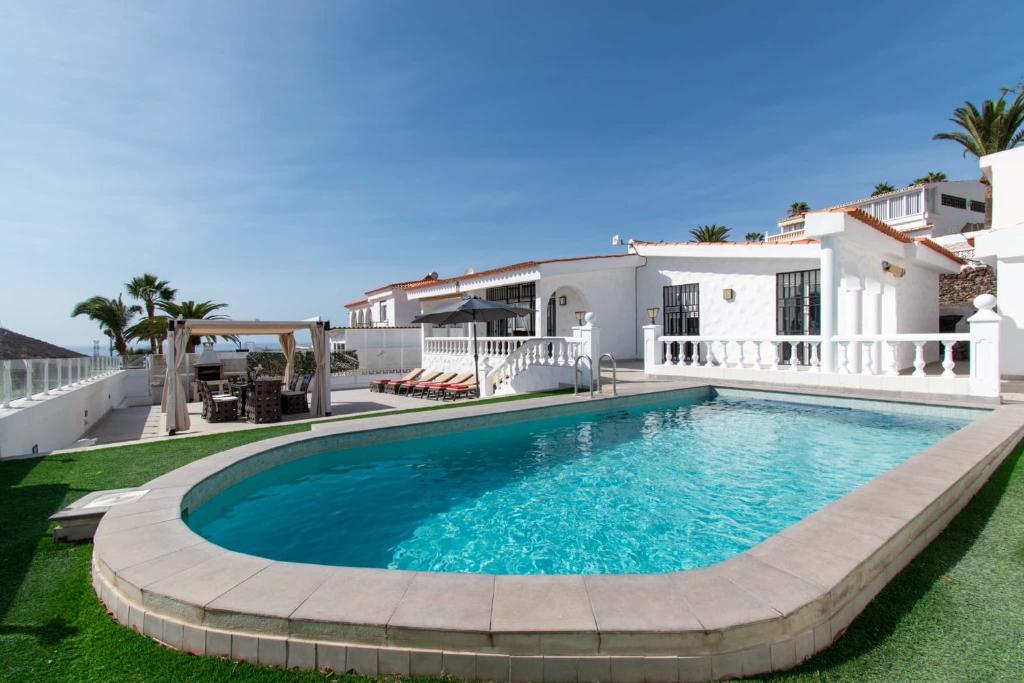 a swimming pool in front of a house at Villa Chayofa in Chayofa