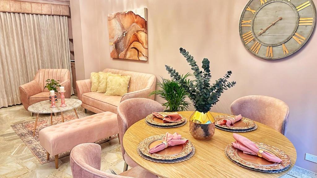 comedor con mesa y reloj en la pared en Apartamento Fantasía Rosa, en Cali