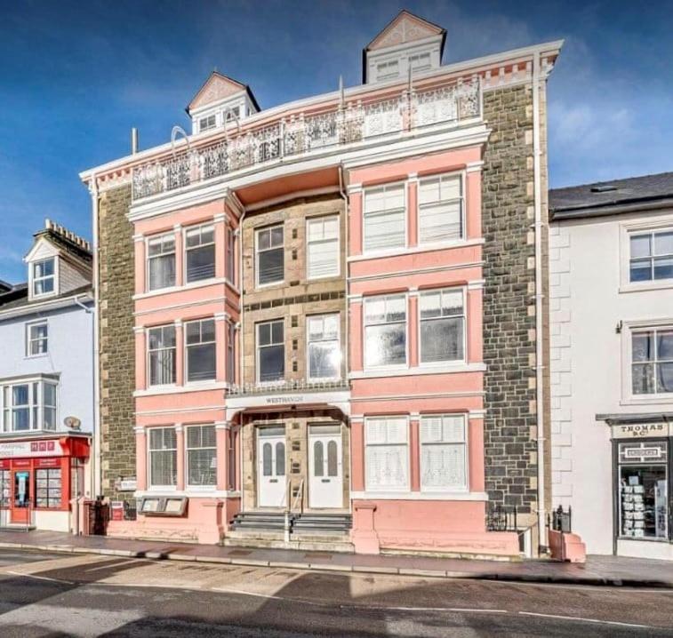 a large red and white building on a street at The Penthouse Westhaven Aberdyfi in Aberdyfi