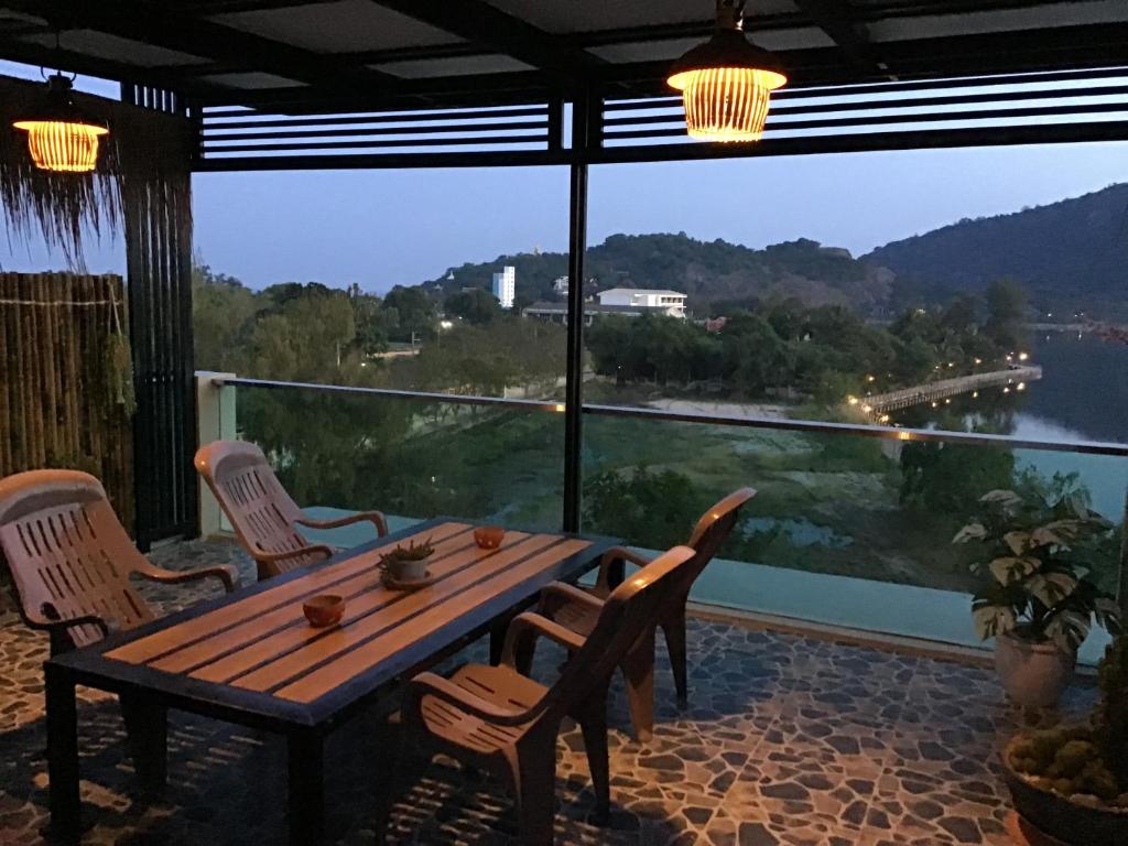 una mesa y sillas en un balcón con vistas en Turtle Nest en Khao Tao