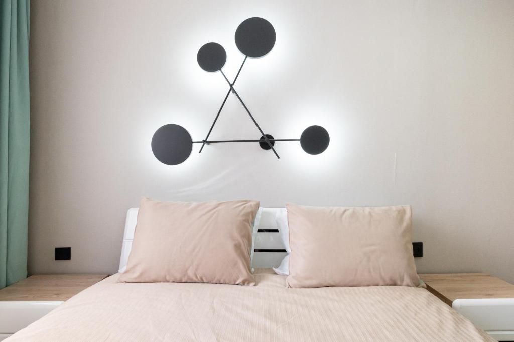 a clock on the wall above a bed at Two Bedroom Apartment In The Heart of Almaty in Almaty