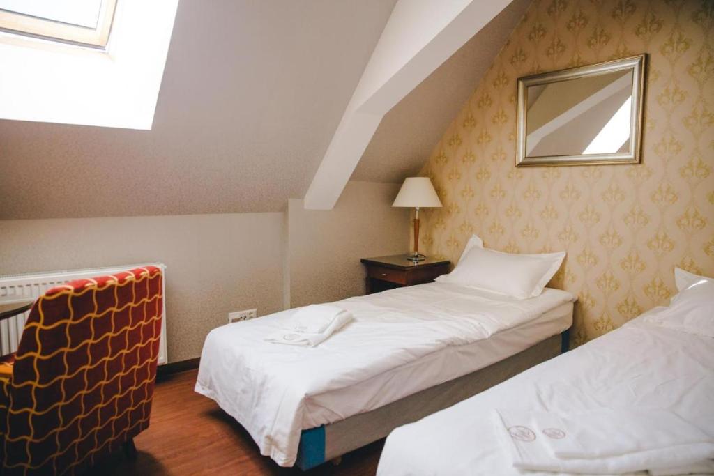 a hotel room with two beds and a mirror at Hotel Luzern Engel in Hitzkirch