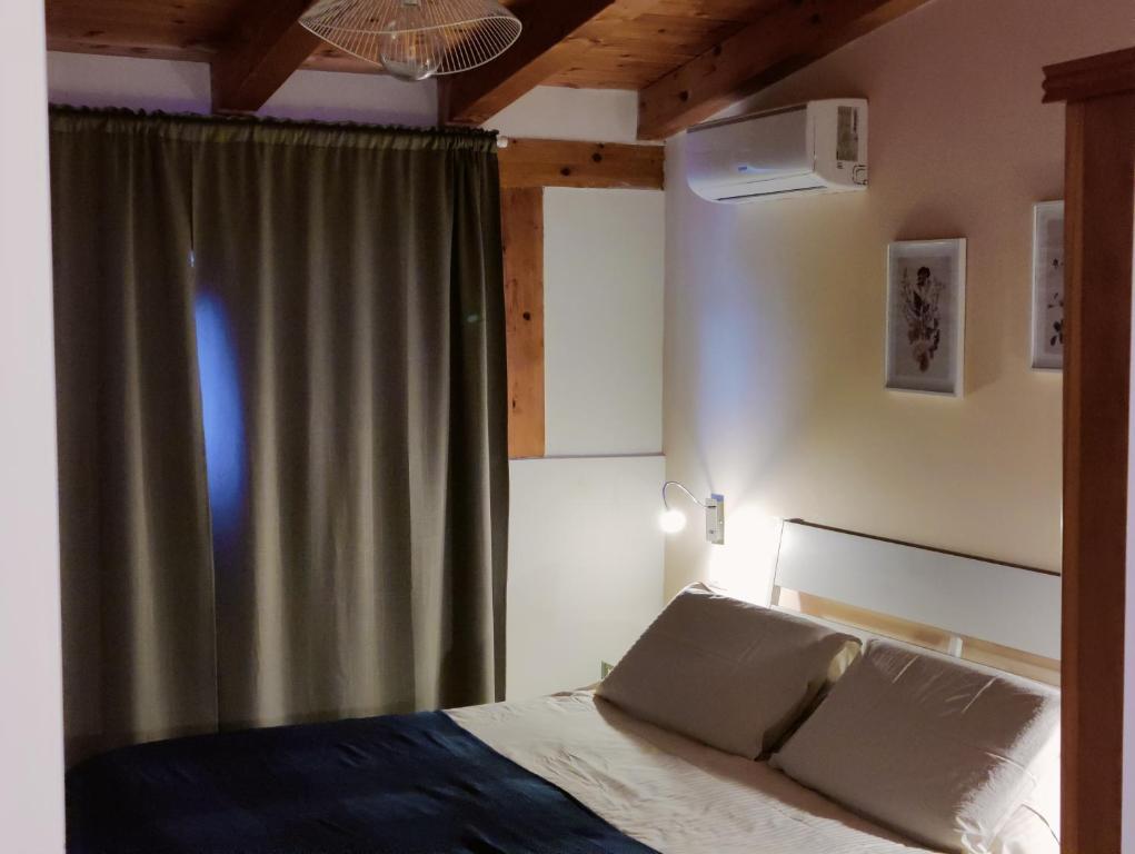 1 dormitorio con cama y cortina en Cuttigghiu Holiday Apartment, en Catania