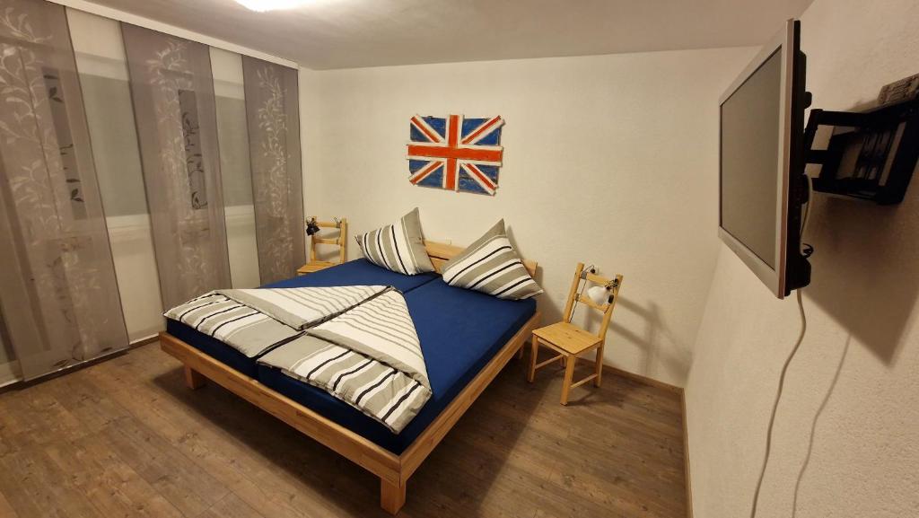 1 dormitorio con 1 cama con bandera en la pared en Doppelzimmer in FEWO Burgau Nähe Legoland, en Burgau
