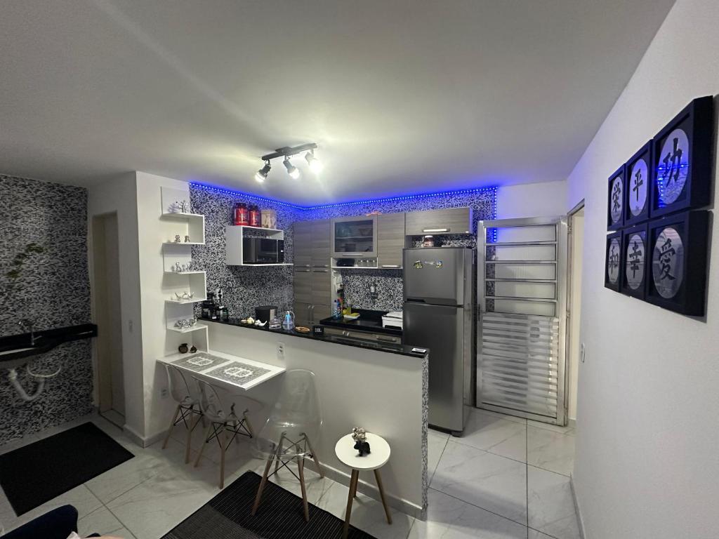 a kitchen with a counter and a refrigerator and a sink at Aero-Quarto Aconchegante in Bayeux