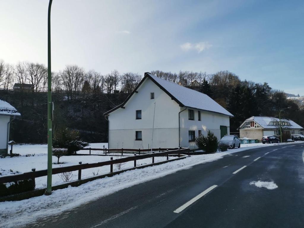 a white house on the side of a snowy road at Ruridylle III in Simmerath