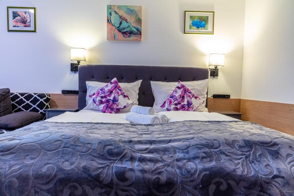 Un dormitorio con una cama grande con sábanas y almohadas púrpuras. en Apparthotel Alte Innbrücke-24Std-Self-Check In, en Neuhaus am Inn