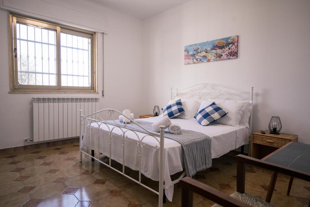 a bedroom with a white bed and a window at Villa del Mirto a 300mt dalla spiaggia, parcheggio privato, animali ammessi in Torre Santa Sabina