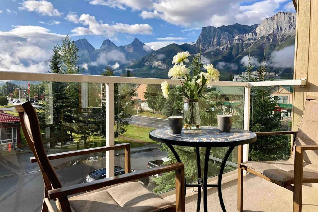 a table on a balcony with a view of mountains at Parkland301 Sunlit 2,000 ft² Penthouse with Mtn View in Canmore