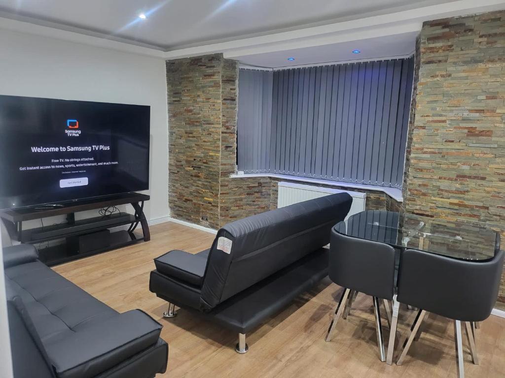 ein Wohnzimmer mit schwarzen Stühlen und einem Flachbild-TV in der Unterkunft Getaway Home in Manchester in Manchester