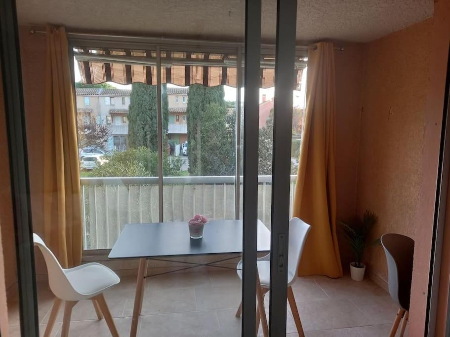 une table et des chaises dans une pièce avec une fenêtre dans l'établissement Beau Studio Mar Vivo, à La Seyne-sur-Mer