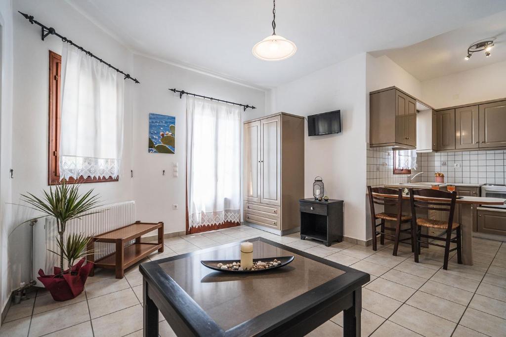 a living room with a table and a kitchen at Elaida Apartments in Apollonia