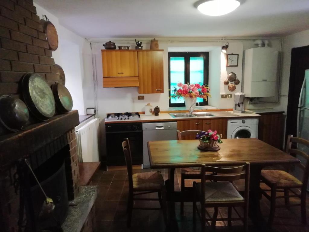 eine Küche mit einem Holztisch und eine Küche mit einem Herd in der Unterkunft VAL GRANDE APARTMENT in Miazzina