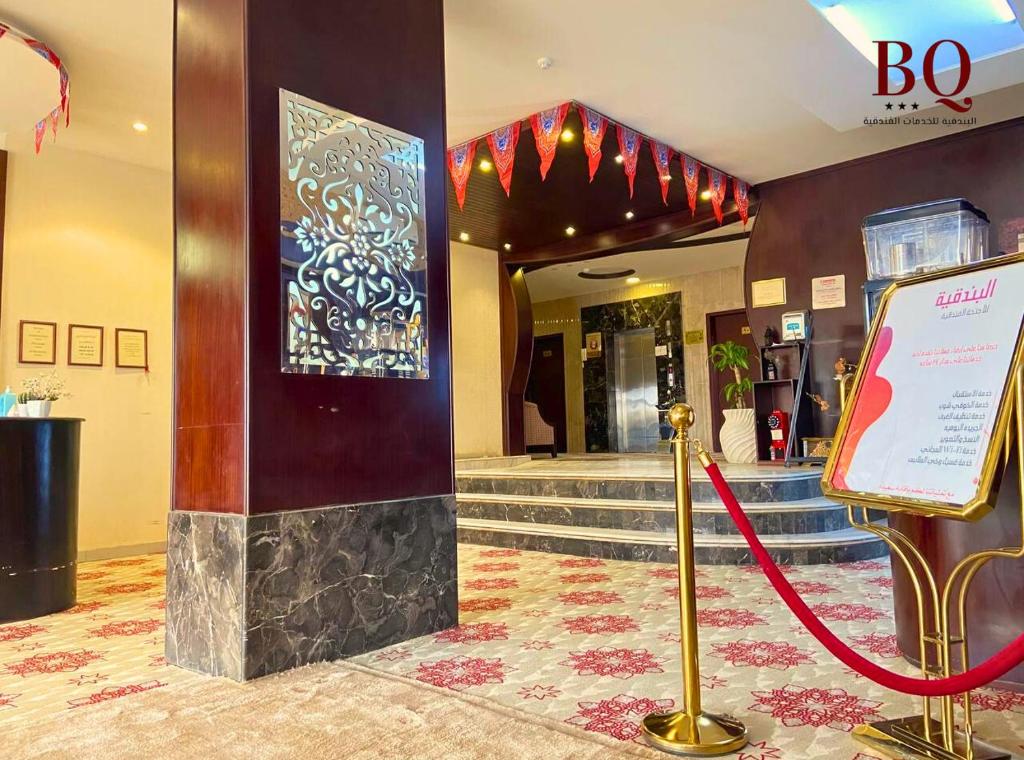 un vestíbulo con una cuerda roja frente a un edificio en البندقية للأجنحة الفندقية بريدة BQ hotel suites en Buraidah