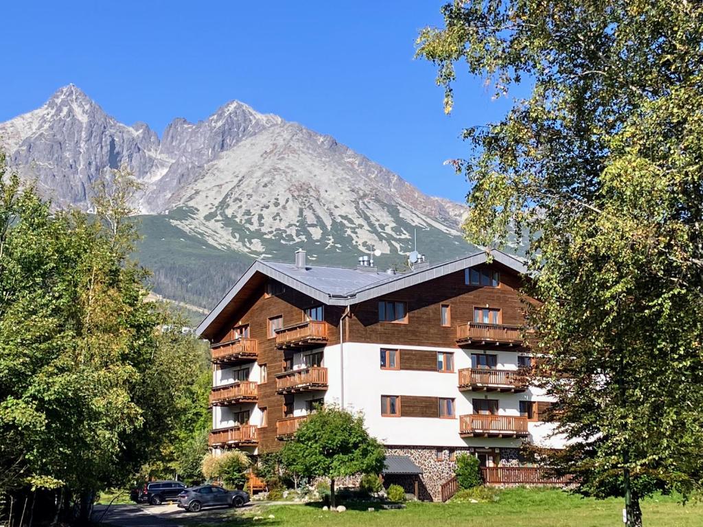 a large apartment building in front of a mountain at Vila Borievka in Tatranská Lomnica