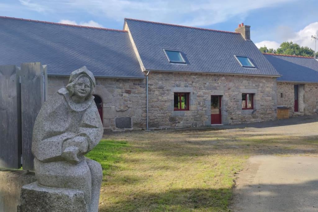 a statue in front of a stone building at L'amour Breizh in Plouaret