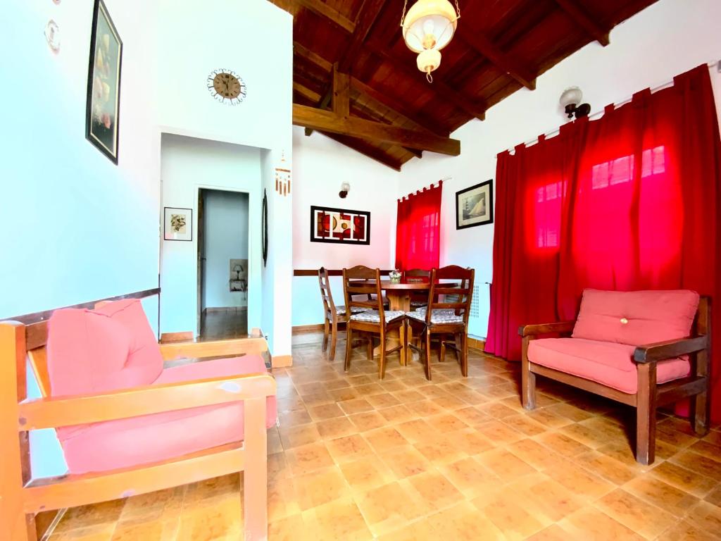 comedor con cortinas rojas y mesa en Complex Quimey alojamiento familiar en Villa Gesell